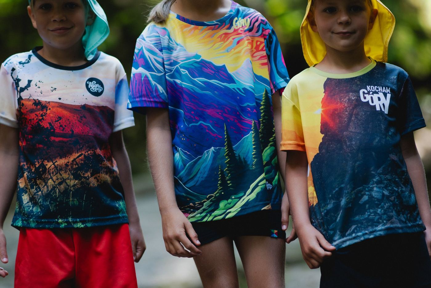 Three children in vivid mountain-print sports shirts